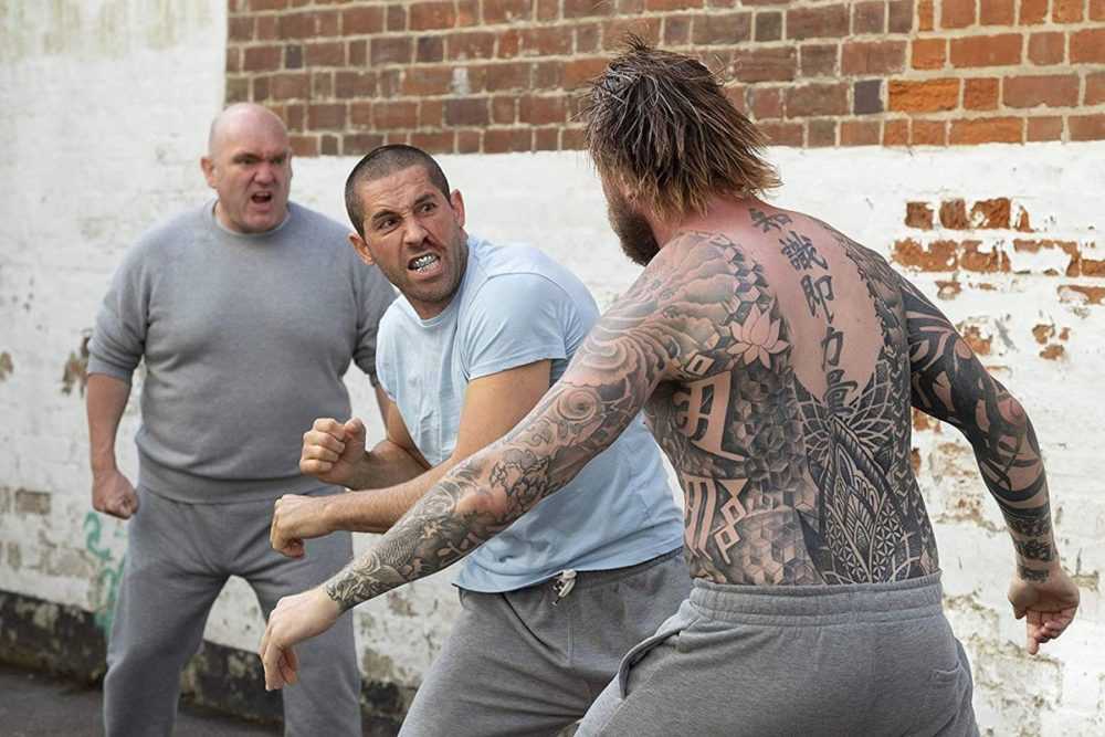 Scott Adkins throws a punch in a prison yard in Avengement